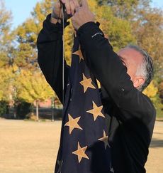 Bill Mork, city facilities supervisor, attaches the 48-star flag to the grommets and raises the flag.
 