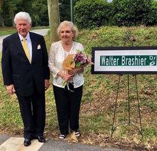  Dr. T. Walter Brashier and his wife, Christine, stand next to a replica of the sign that was unveiled Friday designating the road to the Greer campus.
 