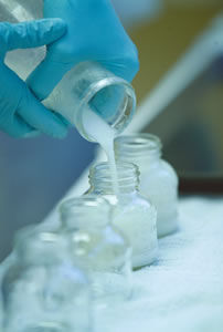 Milk from a donor mother is carefully transferred from milk storage containers to glass flasks.
 
 