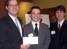 Adam Massey of Greer High School shows off the school's $1,000 grant along with students Tyler Ashwood and Peter Barnett. 