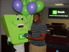Danzel Collins is all smiles receiving his prize from the TD Bank mascot at the Greer branch today.