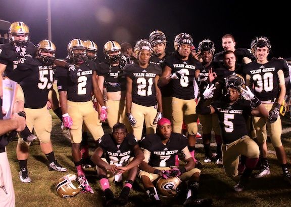 Quez Nesbitt (sitting, 20) accommodated his teammates as he posed for a photo after his record-shattering performance last Friday that vaulted him to Greer's No. 1 all-time rushing leader.