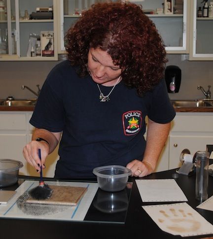 Angie Childers instructs students at the inaugural CSI: Youth Academy on collecting finger prints. Childers is the president of the Greer Police Department Alumni Association.