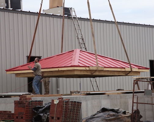 The red top of the aviation tower is lifted to be put in place.
 