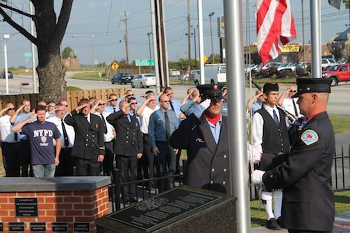 First responders salute the U.S. Flag that is brought to half mast on the anniversary of 9/11.
