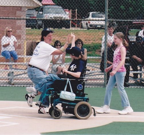 Kim Wooten and Michele Fowler, a former coach in the Mauldin Miracle League, exchange high fives as Wooten slides into home plate.
 