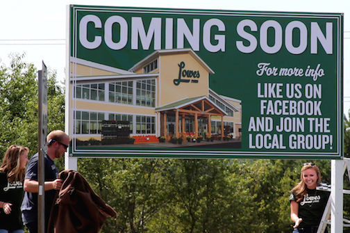 Workers display the Lowes Food sign at the corner of Suber and Hammett Bridge Road.
 