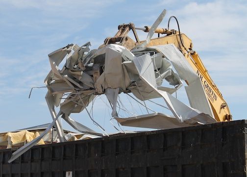 Debris is tossed in a truck where it will be removed from the site.