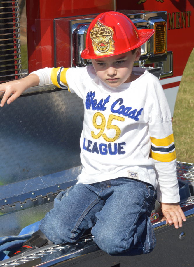 A junior firefighter enjoys playing on the ladder truck of the Lake Cunningham Fire Department.
 