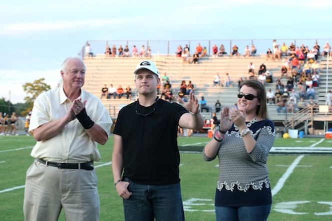 Army Spc. Brett Claycamp was honored Friday night before the Jacket Bowl. Claycamp and his fiance, Catherine Owens, join Greer High School Principal Marion Waters on Dooley Field.