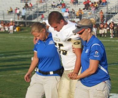 Connor Merrell, center, is helped off the field after injuring his knee in tonigh's scrimmage. 