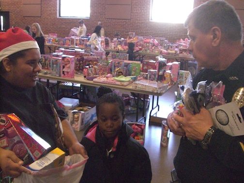 Russ Holthaus, who retires from the Greer Police Department on Dec. 31, has his hands full as he makes the rounds at Cops fo Tots.