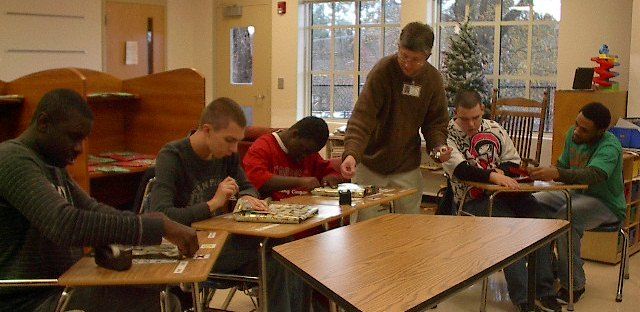 Washington Center students (left to right) Cleveland Davis, Paul Barnett, Xavier Lindsey and  Kyle Johnson with the assistance of teacher, McKenzie Riley, and Para-educator, Anthony Gardner, are working on wrapping presents to give to their families during the holiday season.