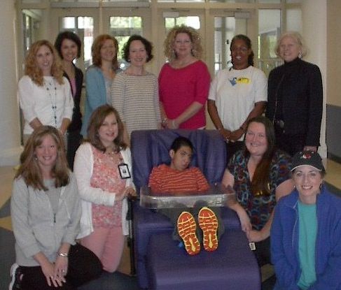 Sara Collins Principal Dr. Melissa Burns and PTA President Shannon Cole donate a positioning chair to Washington Center funded by the Sara Collins PTA. Also pictured are Washington Center student Christian Carmona, PTA members, staff and Principal, Dr. Penny Rogers.