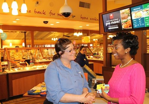 Ryan’s manager Christina Jones congratulates Angela Pride, “Guess The Score” Super Bowl contest winner, while presenting a $50 gift card to the restaurant.