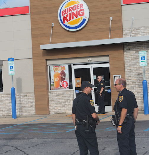 Deputies stand outside of Burger King while the crime scene is processed.
 